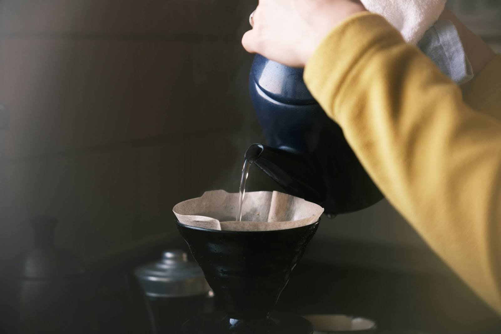 A kettle pouring water into a coffee dripper