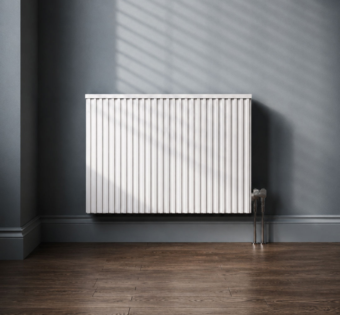 Modern white Fischer German electric heating system mounted on a grey-blue wall, showing vertical radiator fins and chrome pipework.