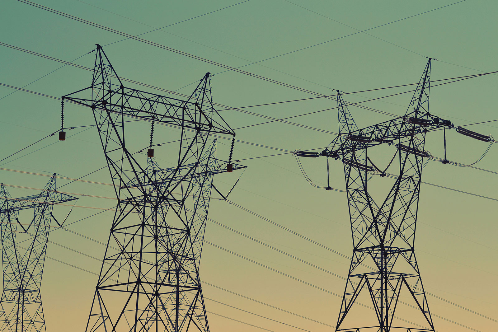Electricity pylons and power lines against a clear sky, representing the UK energy grid and the shift toward modern smart tariffs.