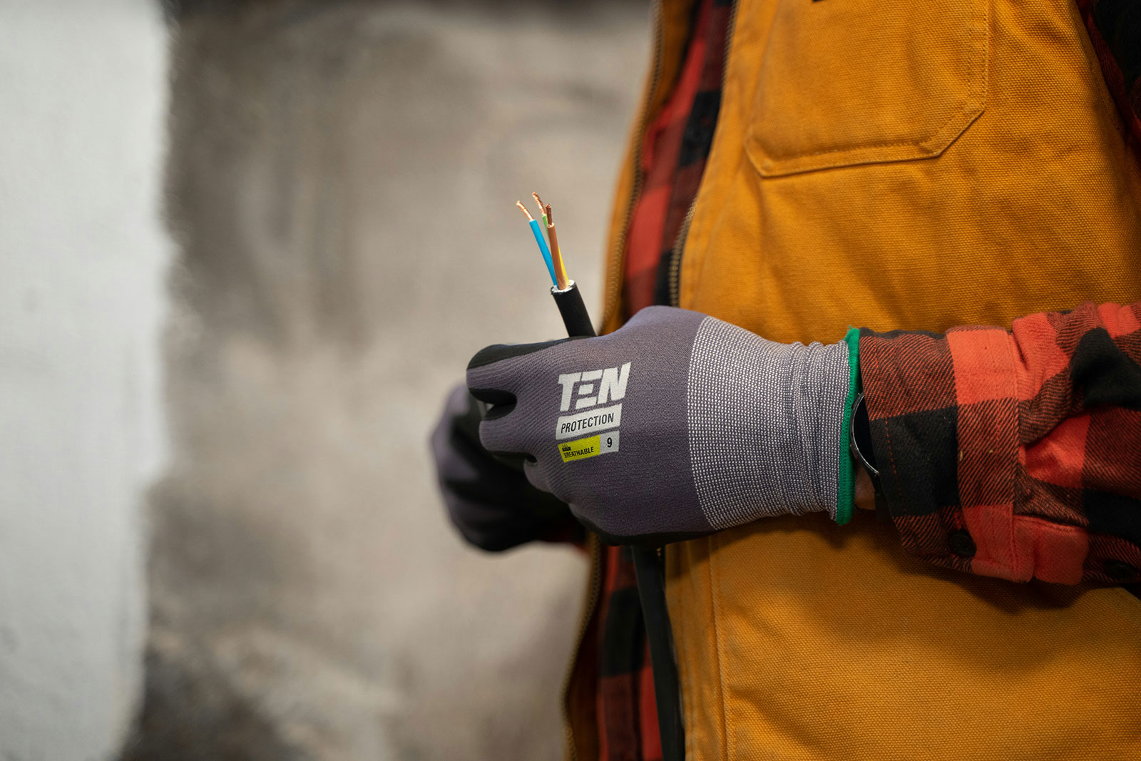 Electrician holding electrical cable during an electric boiler installation in a UK home