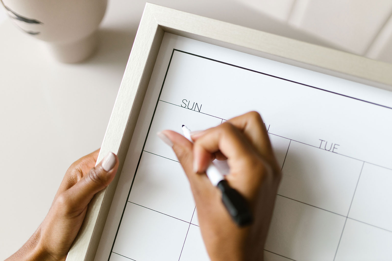 Person filling in a weekly planner to organise a winter heating schedule around their routine.